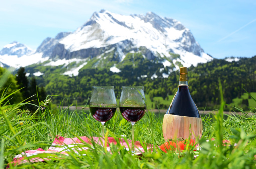 Wine and vegetables served at a picnic on Alpine meadow. Switzerland