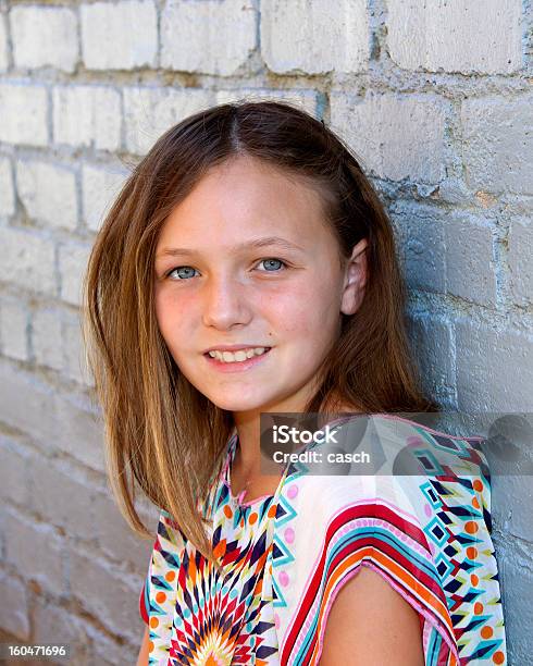 Young Girl Fuertemente Contra Una Pared De Ladrillo Blanco Foto de stock y más banco de imágenes de 12-13 años