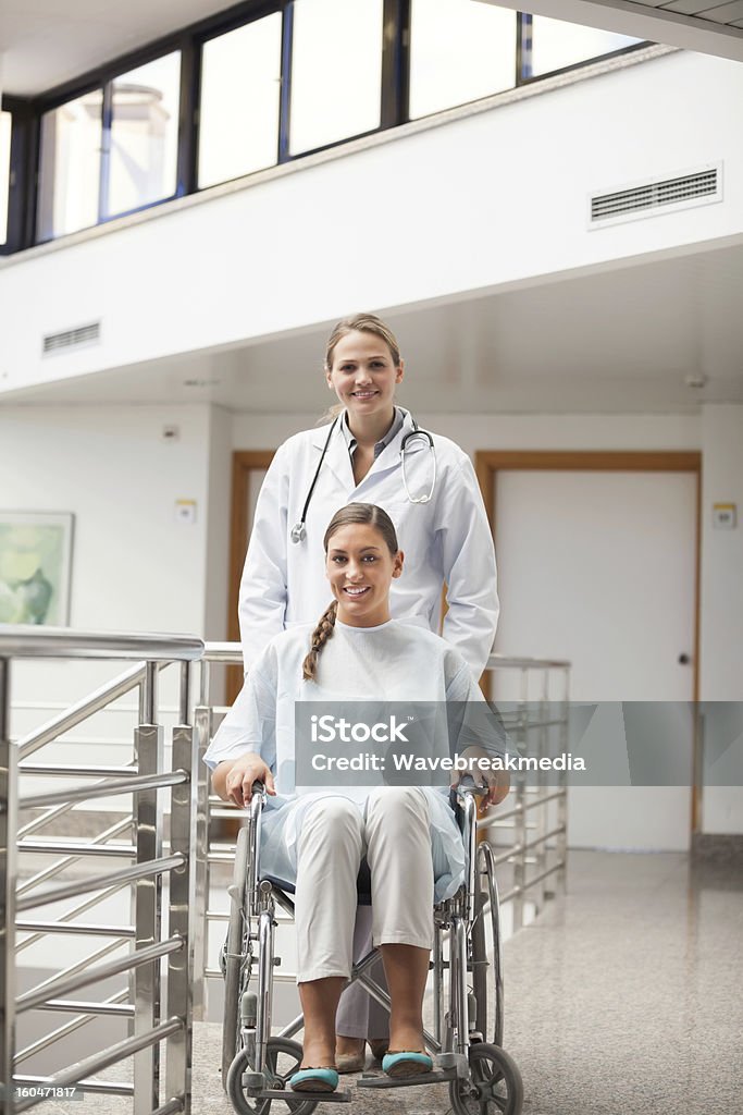 Doente sentado em uma cadeira de rodas ao lado do médico - Royalty-free 20-29 Anos Foto de stock