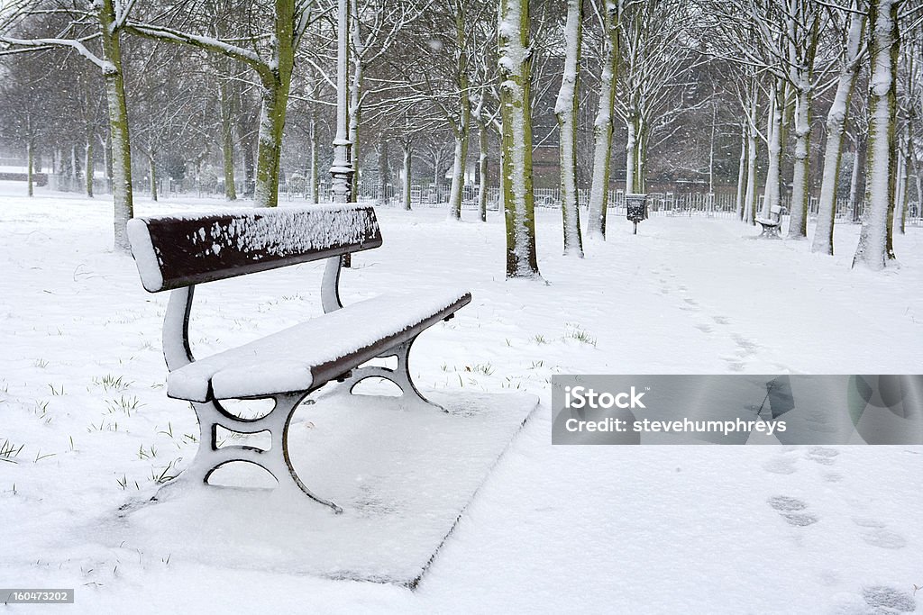 Banco del parque en la nieve de invierno - Foto de stock de Acera libre de derechos