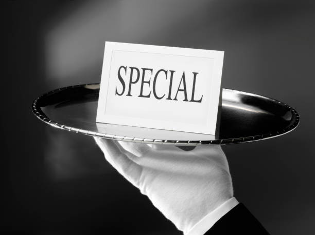 Someone Special with First Class Service First class service. Waiter holding a special card on a silver tray.  silver platter stock pictures, royalty-free photos & images