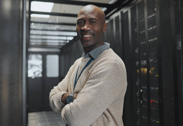 istock Black man, IT technician in server room and portrait with smile, company mainframe and software update. Network, datacenter and cybersecurity. African male and engineering with digital infrastructure 1604758751