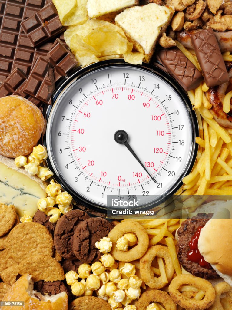 Cibo ad alto contenuto calorico e di un peso bilance - Foto stock royalty-free di Alimentazione non salutare