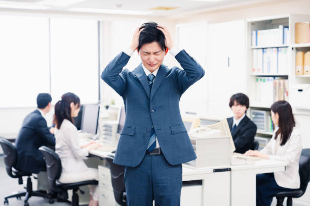 彼のオフィスに頭を持つ若い実業家 - 仕事ストレス ストックフォトと画像