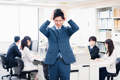 Young businessman with his head in his office