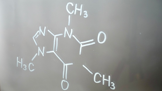 Chemical structure, formula of caffeine on glass in the lab close-up. Lecture on chemistry