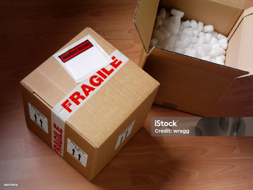 Open and Closed Cardboard Box Open and closed cardboard boxes wrapped with fragile labels and polystyrene, to show you care. Fragile Sign Stock Photo