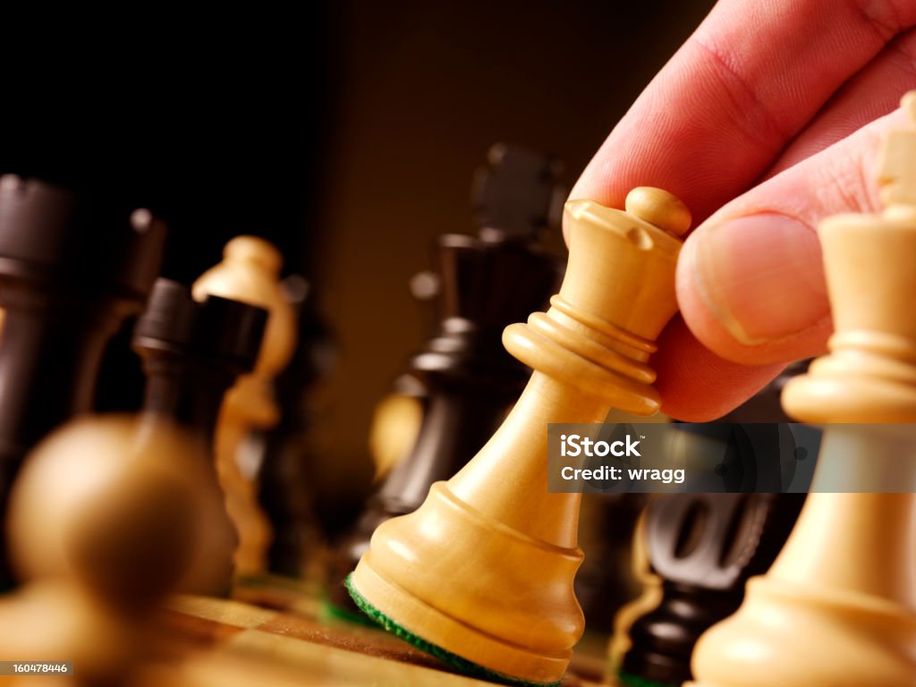 Moving a Chess Queen Moving the queen in a game of chess. Achievement Stock Photo