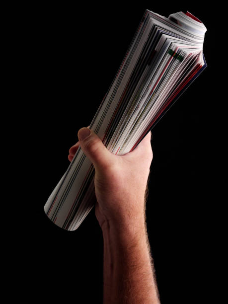 Rolled Up Magazine Holding up a rolled up magazine. rolled up magazine stock pictures, royalty-free photos & images