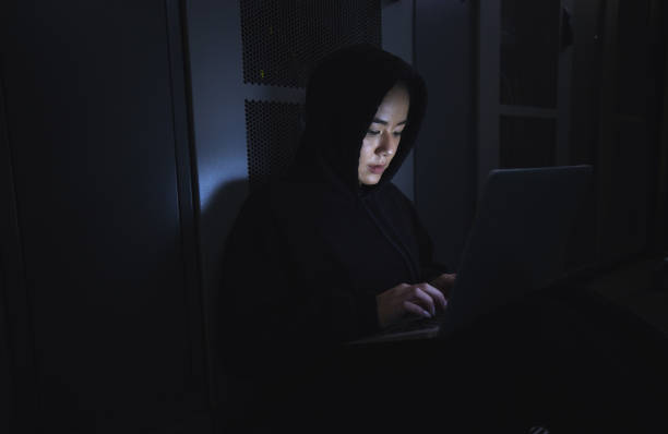 istock Hacker, server room and person on laptop for coding software, data center crime and cyberpunk in dark. Network hacking, woman or user in cybersecurity, information technology or programmer ransomware 1604805255
