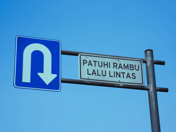 istock a traffic sign symbolizing a U-turn with an Indonesian-language warning that reads obey traffic rules. Photo of a traffic sign with a blue sky background 1604805855