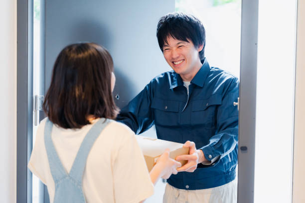 istock Young man delivering a parcel with a smile 1604805863