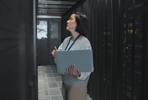 istock Woman with laptop, server room and information technology, engineer and datacenter with software update. Tech industry, cybersecurity and network with Asian female setting up firewall and database 1604808978