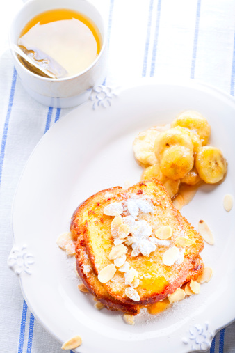 French toast  with bananas in caramel, nuts, powdered sugar and green tea
