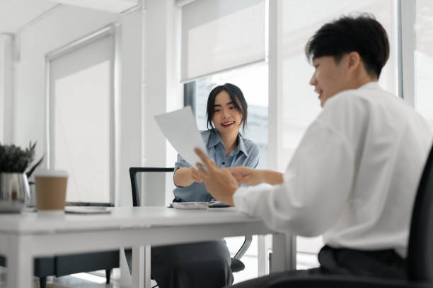 istock Two Asian colleagues discussing work Businessman holding a tablet in the office 1604819105
