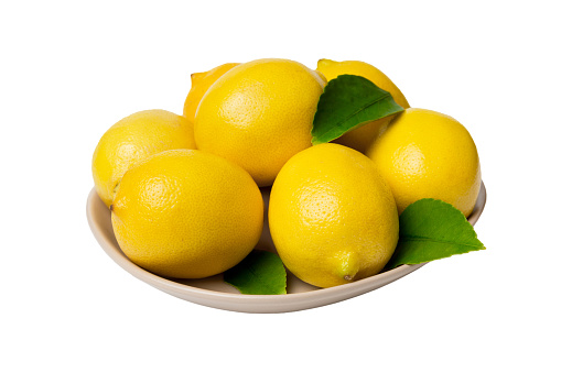 Fresh cutted lemon and whole lemons over round plate isolated on white background. Food and drink ingredients preparing. healthy eating theme top view with copy space.