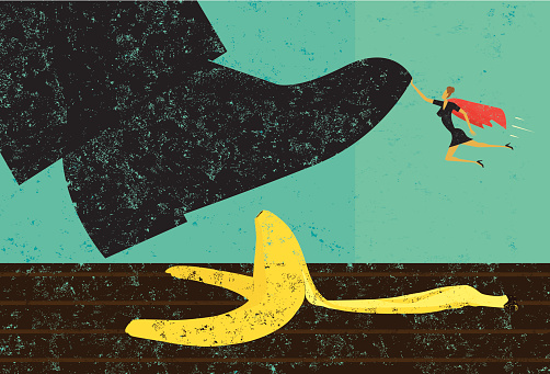 A miniature, super businesswoman saves someone from slipping on a banana peel. The shoe, woman, and banana peel are on a separately labeled layer from the background.
