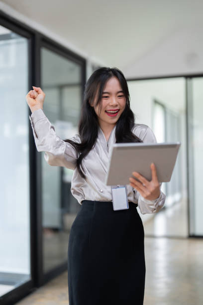 istock Young businesswoman working successfully in office while standing near window 1604825134