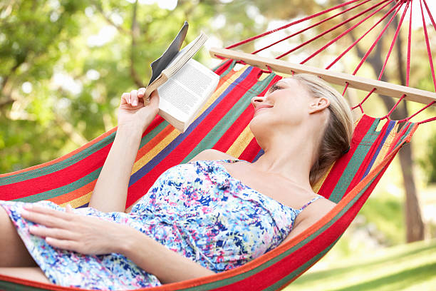 istock Woman Relaxing In Hammock With Book 160483870