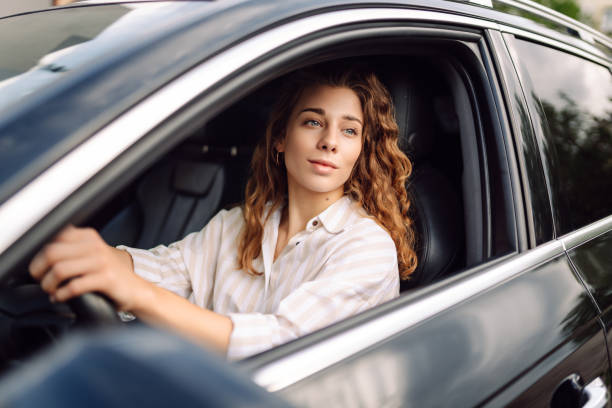 istock Beautiful smiling woman driving a car. 1604841127