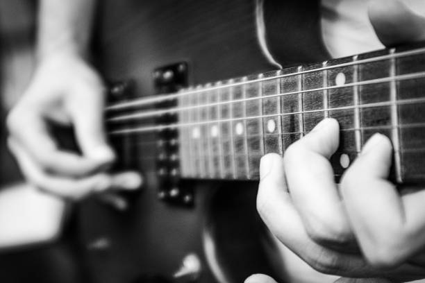istock Fingers Playing Electric Guitar Black White 1604869610