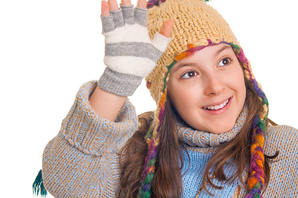 istock Smiling young girl in warm winter clothes waving hand 160487144