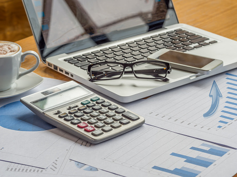 office equipment and paper graph on wooden table