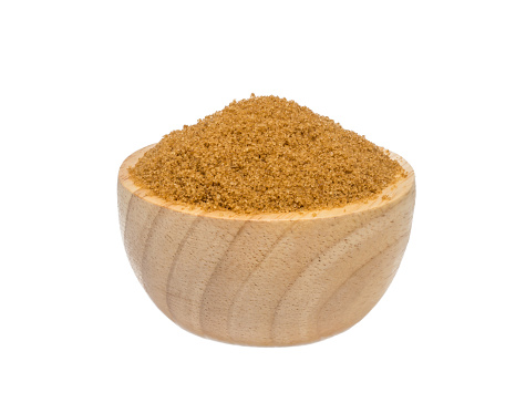 isolate white background of brown sugar in a wooden bowl