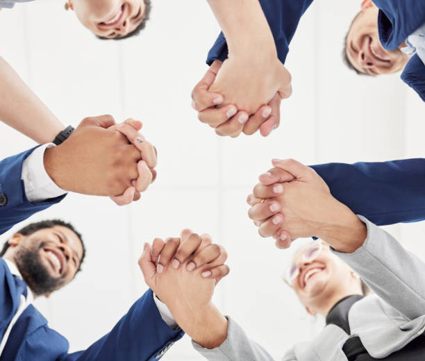 istock Team building, support or happy business people holding hands for collaboration, motivation or community. Vision, low angle or excited group of workers with smile, mission goals or target together 1604879309