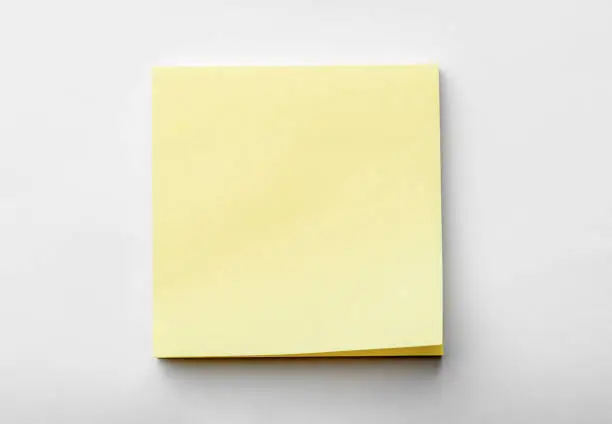 Photo of blank pastel yellow sticky notes packaging on white background. Mockup sticky Note Paper. Use post it notes to share idea on sticky note. sheets for notes.