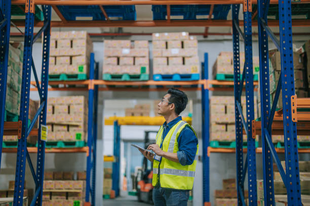 istock Asian Chinese foreperson taking inventory checking online order using digital tablet for delivery arrangement 1604891229