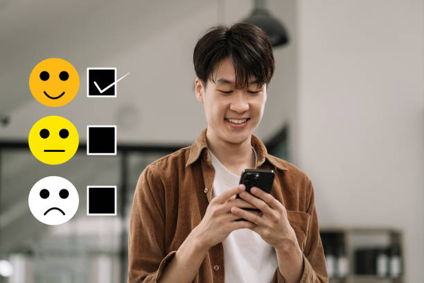 istock Male holding a digital smartphone with checkboxes rating smiley faces excellent for Satisfaction Survey, Happy Client Customer Experience concept. 1604896719