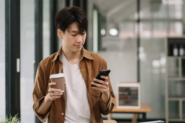 istock young man using smartphone payments online shopping at office. 1604896782