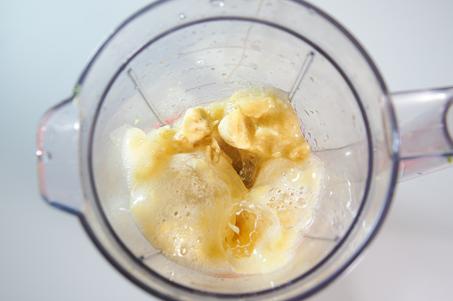 banana with milk in the food processor view from above