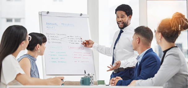 Businessman, coaching and meeting on whiteboard for planning, strategy or idea in boardroom at office. Black man mentor coach training staff or business people in corporate presentation at workplace