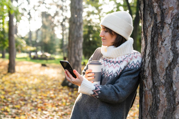 istock A woman is holding a phone and a cup 1604911419