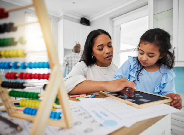 istock Teaching, math and mother with kid home education, learning and support for child development. Parents, woman or family helping girl with numbers, drawing and creative writing together at their house 1604924033