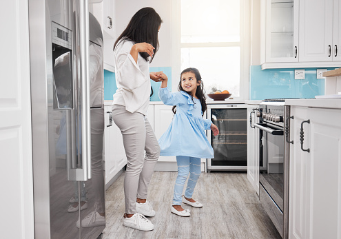 Mother, dancing and girl in the kitchen with bonding, parent care and love in a family home. Mom child and happy dance in a house with happiness, fun and dancer activity with mama support in morning
