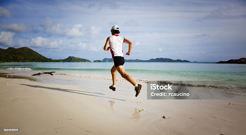 Mann läuft auf einem tropischen Strand - Lizenzfrei Baseballmütze Stock-Foto