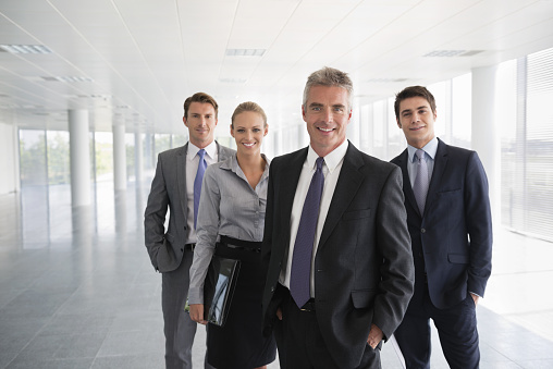 Portrait of confident business team standing together in empty office building.