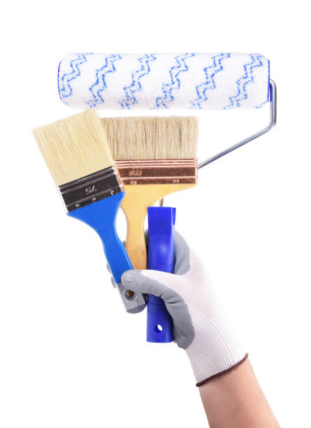 istock Hand with brush and roller on a white background. 1604949329