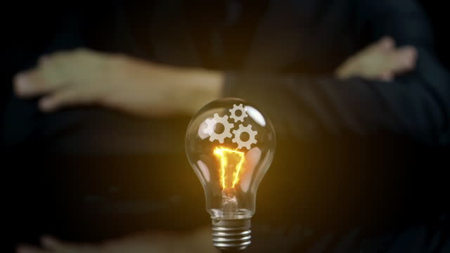 Businessman showing glowing Light bulb with virtual mechanical gear for creative thinking idea concept and future innovative technology. Creative, inspiration and imagination.