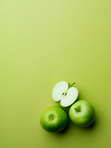 Apples on green paper background.  Copy space.