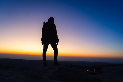 Silhouette of a woman with sunrise gradient in the background