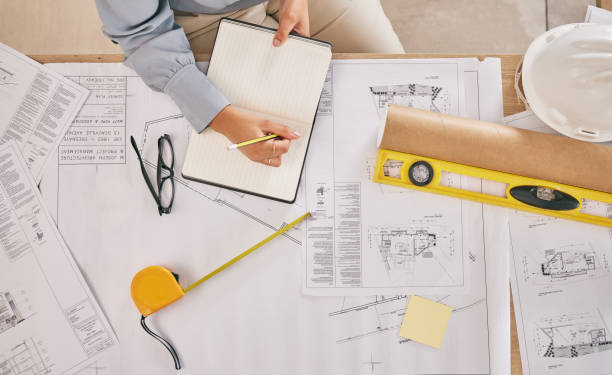 istock Above, blueprint and hands with notes for architecture, construction planning and building design. Desk, architect and writing a goal for infrastructure ideas, creativity and a contractor strategy 1605016015