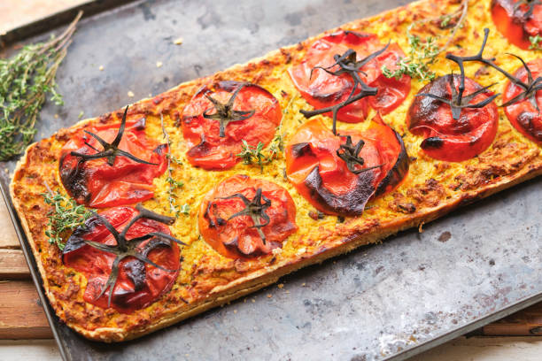 istock Delicious flatbread with tomato slices and thyme sprigs 1605029022