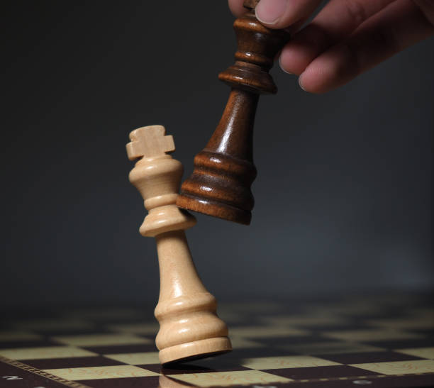 istock Hand on chessboard and pieces flying. Cloudy background 1605035673