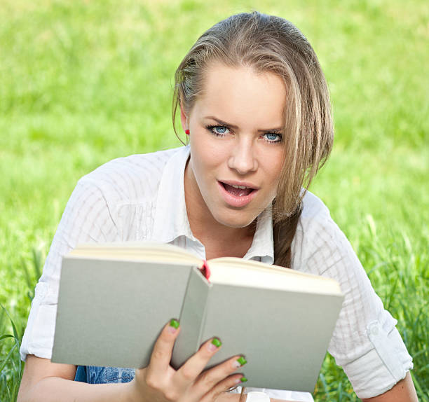 istock Young woman reading book 160503918
