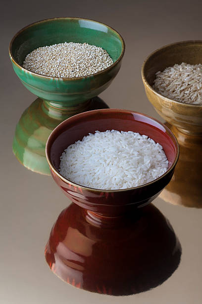 Three bowls with balsamic, brown rice and quinoa stock photo