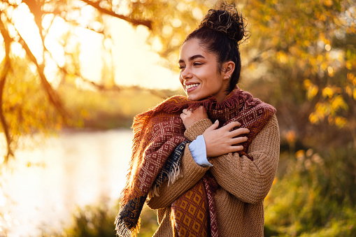Beautiful young woman enjoying a carefree autumn day outdoors.